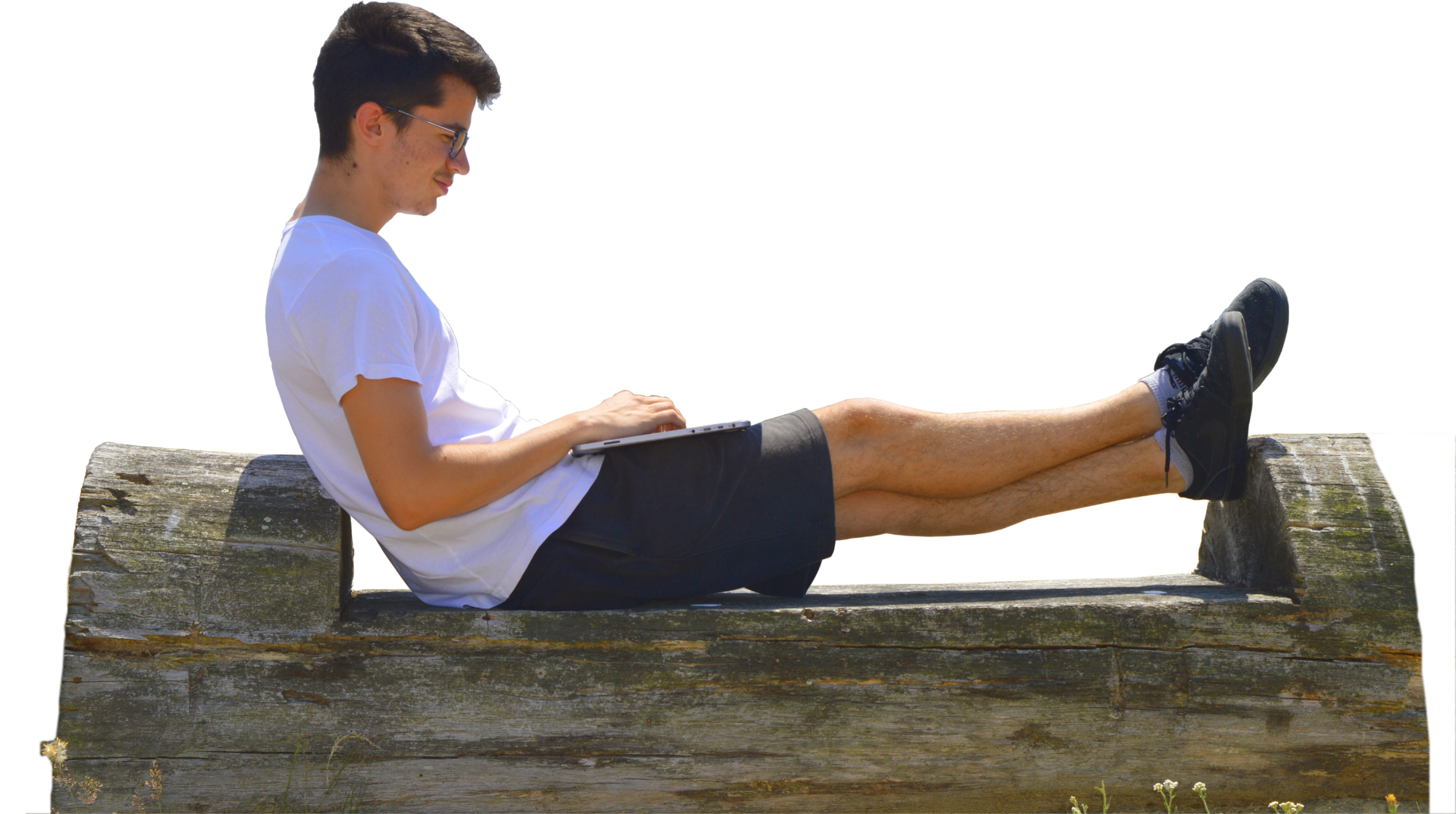 Garçon en t-shirt blanc assis sur un tronc d'arbre